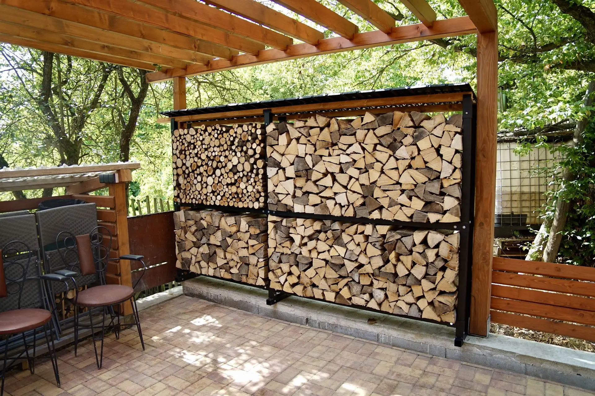 Dřevníková stěna pod pergolou na zahradě